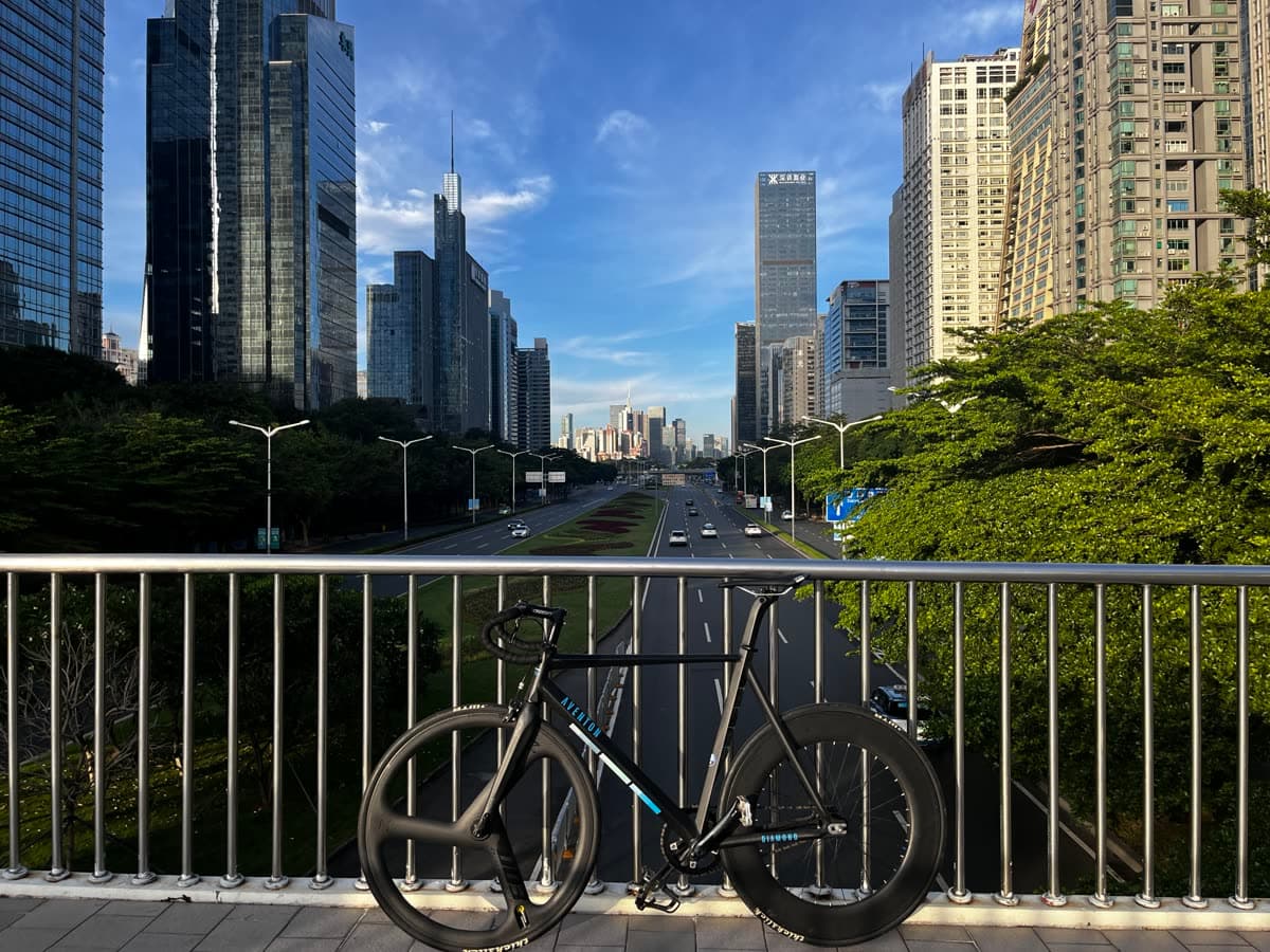 Track bike on a bridge with the Futian CBD skyline